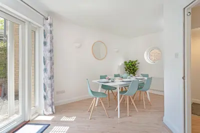 a dining room with a white table and blue chairs at 2 Bedroom City Centre Townhouse - with Parking in Cambridge