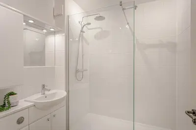 a white bathroom with a shower and a sink at 2 Bedroom City Centre Townhouse - with Parking in Cambridge