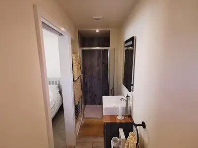 a small bathroom with a sink and a shower at The Garden Room in Leiston