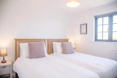 two beds sitting next to each other in a bedroom at 3 Oaks Court, Thorpeness in Thorpeness