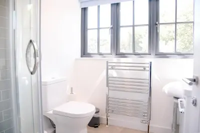 a white bathroom with a toilet and a window at 3 Oaks Court, Thorpeness in Thorpeness