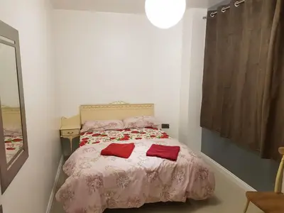 a bedroom with a bed with two red pillows on it at Orwell Suite in Ipswich