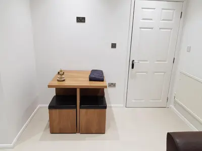 a small wooden table in a room with a door at Orwell Suite in Ipswich