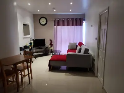 a living room with a couch and a table and a clock at Alhambra Suite in Ipswich