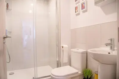 a bathroom with a shower and a toilet and a sink at Sutton House, Woodbridge in Woodbridge