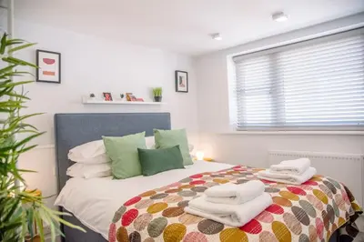 a bedroom with a bed with towels on it at Sutton House, Woodbridge in Woodbridge