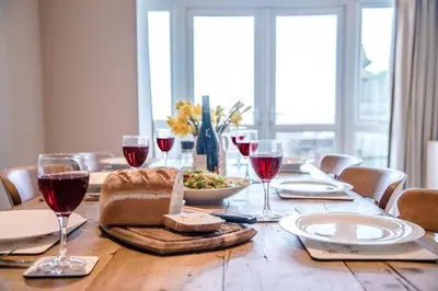 a wooden table with wine glasses and food on it at Tower House, Aldeburgh in Aldeburgh