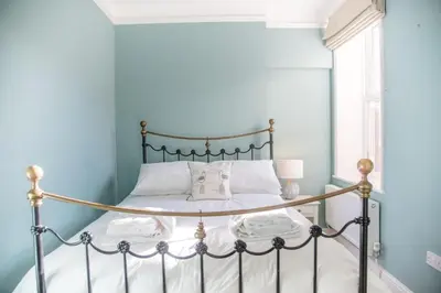 a bedroom with a bed with a metal frame at Tower House, Aldeburgh in Aldeburgh