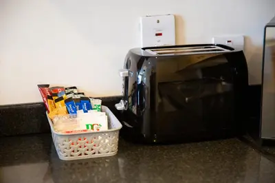 a black toaster oven with a basket next to it at 1-bedroom apartment with balcony, Hoddesdon in Hoddesdon