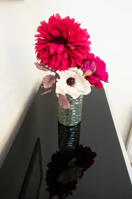 a vase filled with red and white flowers on a table at 1-bedroom apartment with balcony, Hoddesdon in Hoddesdon