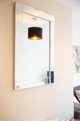 a mirror on a wall above a bathroom sink at 1-bedroom apartment with balcony, Hoddesdon in Hoddesdon