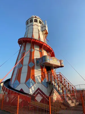 a red and white lighthouse with a roller coaster at KellysHolidayHomes Atlas 3 bedrooms caravan in Weeley