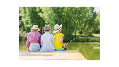 four people sitting on a dock fishing on a lake at KellysHolidayHomes Atlas 3 bedrooms caravan in Weeley
