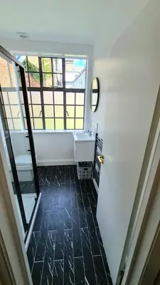 a bathroom with a sink and a window at Cuckoo Rooms in Colchester
