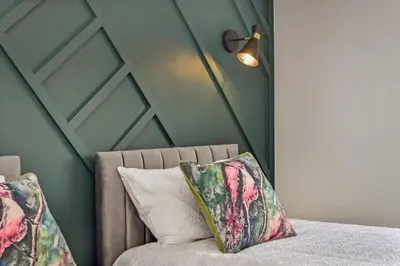 a bed with two pillows and a lamp in a room at Cuckoo Rooms in Colchester