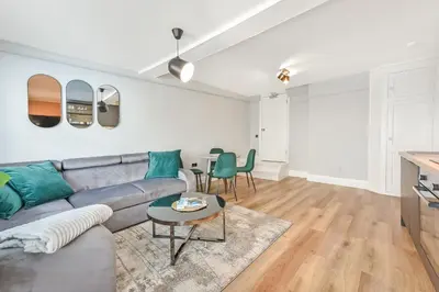 a living room with a gray couch and a table at Cuckoo Rooms in Colchester