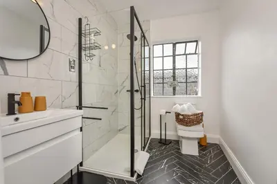 a bathroom with a shower and a toilet and a sink at Cuckoo Rooms in Colchester