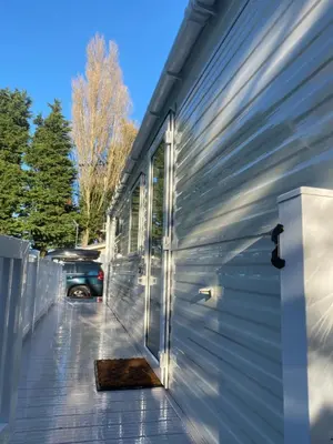 a side view of a house with a garage at Kellys Holiday Homes 24 Willerby 2 bedrooms caravan in Weeley