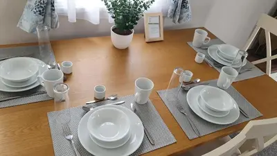 a dining room table with white plates and utensils at Kellys Holiday Homes 24 Willerby 2 bedrooms caravan in Weeley
