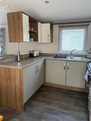a kitchen with white cabinets and a sink at Kellys Holiday Homes 24 Willerby 2 bedrooms caravan in Weeley