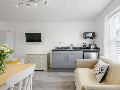 a living room with a table and a kitchen at The Gardens in Santon