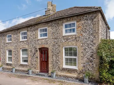 an old stone house with a red door at The Gardens in Santon