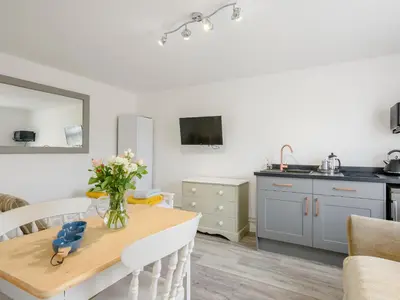 a kitchen with a table with a vase of flowers on it at The Gardens in Santon