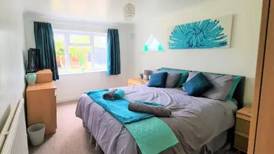 a bedroom with a bed with blue pillows on it at Westbury House in Rochford