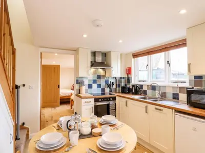 a kitchen with a wooden table with plates on it at The Cart Lodge in Halstead