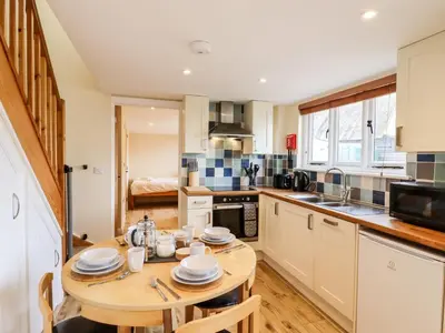 a kitchen with a wooden table and a small kitchen with a table at The Cart Lodge in Halstead