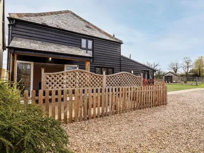 a wooden fence in front of a house at The Cart Lodge in Halstead