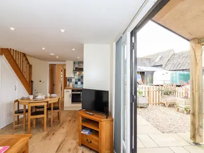 a kitchen and living room with a television and a table at The Cart Lodge in Halstead