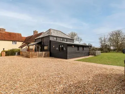 a black house with a gravel driveway at The Cart Lodge in Halstead