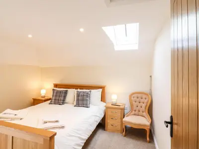 a bedroom with a bed and a desk and a chair at The Cart Lodge in Halstead