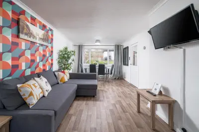 a living room with a couch and a flat screen tv at Skyvillion-STEVENAGE Amazing 3Bed House, Garden, Free Off Street Parking for 2 Cars, WiFi in Stevenage