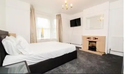 a hotel room with a bed and a fireplace at Charming Victoria Conversion Flat in Brentwood with a Garden & Free Parking in Brentwood
