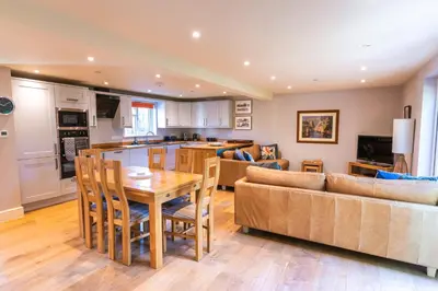 a kitchen and living room with a table and a couch at Garden Villa in Cambridge