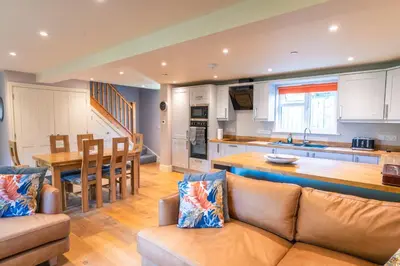 a kitchen and living room with a couch and a table at Garden Villa in Cambridge