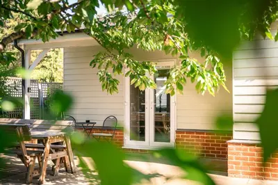 a porch of a house with a table and chairs at Garden Villa in Cambridge