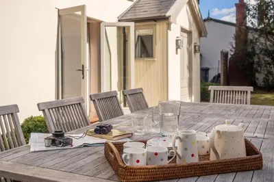 a picnic table with a tray of cups and mugs at Alexander House in Thorpeness