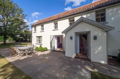 an external view of a white house with a patio at Alexander House in Thorpeness