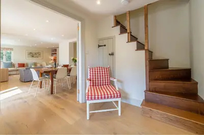 a living room with a staircase and a dining room at Alexander House in Thorpeness