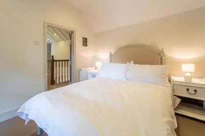 a bedroom with a large bed with white sheets and pillows at Alexander House in Thorpeness