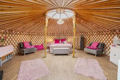 a room with a bed and chairs in a yurt at Glamp and Tipple Ltd in Great Ellingham