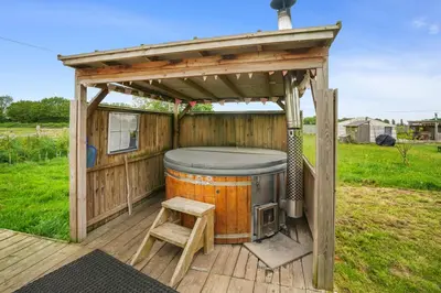 a gazebo with a hot tub on a deck at Glamp and Tipple Ltd in Great Ellingham