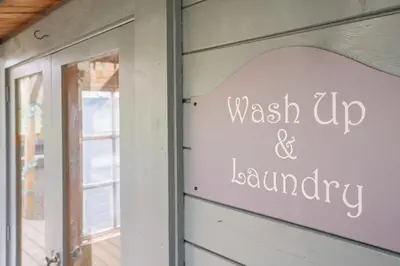 a sign that reads wash up and sanctuary on the side of a building at Glamp and Tipple Ltd in Great Ellingham