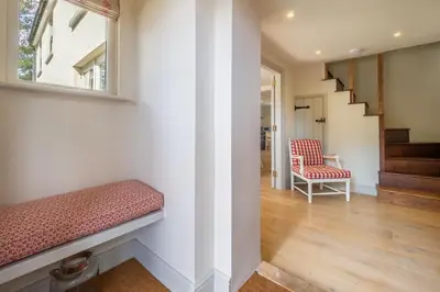 a hallway with a bench and a stair case at Alexander House 4 in Thorpeness