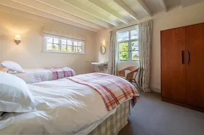 a bedroom with two beds and a window at Alexander House 4 in Thorpeness