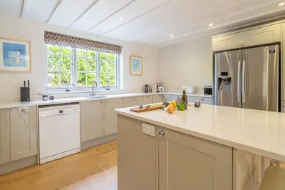a large kitchen with white cabinets and a counter top at Alexander House 6 in Thorpeness