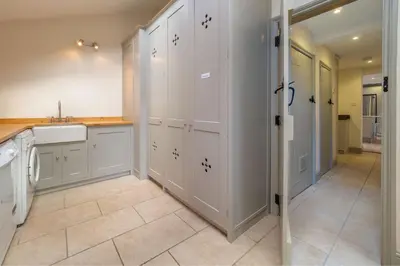 a kitchen with white cabinets and a sink at Alexander House 6 in Thorpeness